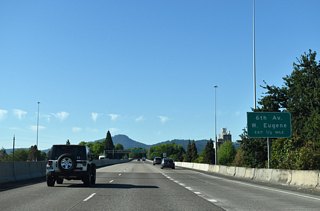 An auxiliary lane joins the freeway as I-105 / OR 126 span the Willamette River south into Eugene. The Eugene-Springfield Highway concludes one half mile ahead at W 7th Avenue (OR 99 south / OR 126 Business east). OR 126 west follows OR 99 north along W 6th Avenue from I-105 into the western neighborhoods of Eugene.