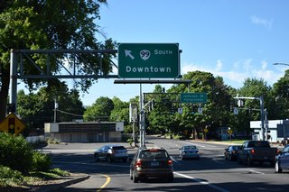 I-105 lowers from the viaduct over Washington Jefferson Park and W 6th Avenue (OR 99 north) to an intersection with W 7th Avenue and Jefferson Street.