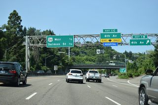 Exit 1 B leaves for SW 4th Avenue ahead of a lane drop at Exit 1 C for SW 6th Street. U.S. 26 west joins the Stadium Freeway from SW 6th Avenue only to leave at Exit 1 D along Sunset Highway to Beaverton in one half mile.