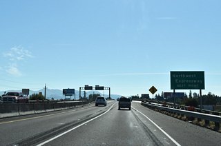 OR 569 turns east as the Randy Papé Beltline spans Prairie Road and a series of railroad lines ahead of a folded diamond interchange with Northwest Expressway.