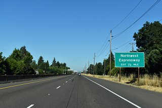 Northwest Expressway converges with OR 569 at the succeeding exit westbound. The controlled access arterial parallels the Amtrak line alongside a residential area from River Road 4.5 miles north to Prairie Road and Irvington Drive.