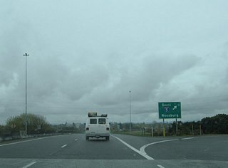 Belt Line Road transitions into the Randy Pepe Beltline west of the intersection with Gateway Road. Traffic funnels onto the freeway from The Shoppes at Gateway retail area and Game Farm Road ahead of the cloverstack interchange with I-5. The exchange was reconfigured with the addition of a flyover ramp from I-5 north to OR 569 west by November 2008.