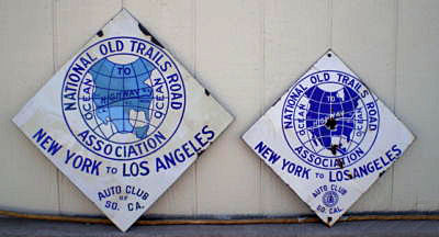 The right sign (15 inches) is from California, and the left one (18 inches) is from either California or one of the other states along the route (likely New Mexico, almost certainly west of Kansas City). The small shield is about 1928, the larger 1913.