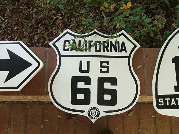 Replica state and US highway markers, installed on location. White guide sign dates back to 1938.