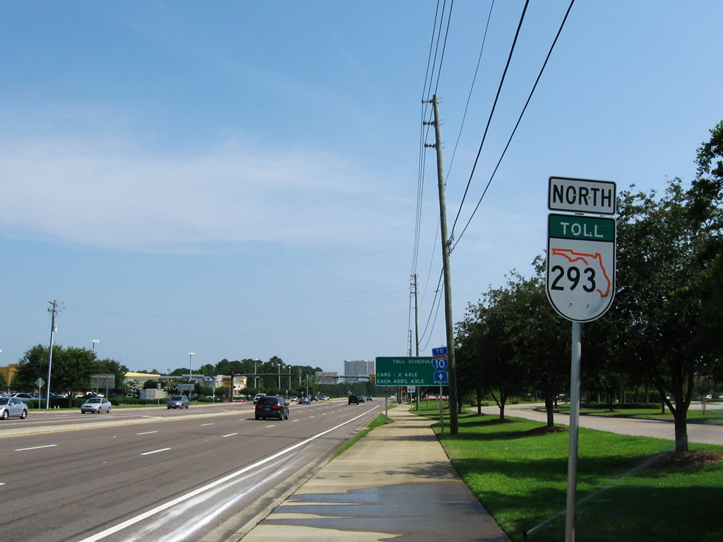 First northbound Florida 293 toll shield just north of its southern terminus with U.S. 98 in Destin. This is the only toll shield for Florida 293 that shows an orange Florida outline instead of the typical black outline. The orange outline is typical of Orlando area toll expressways.