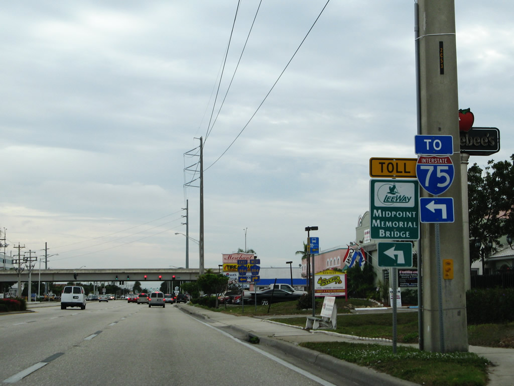 Trailblazer for the Midpoint Memorial Bridge on Lee County 867A (Del Prado Boulevard) southbound approaching the interchange with Lee County 884.