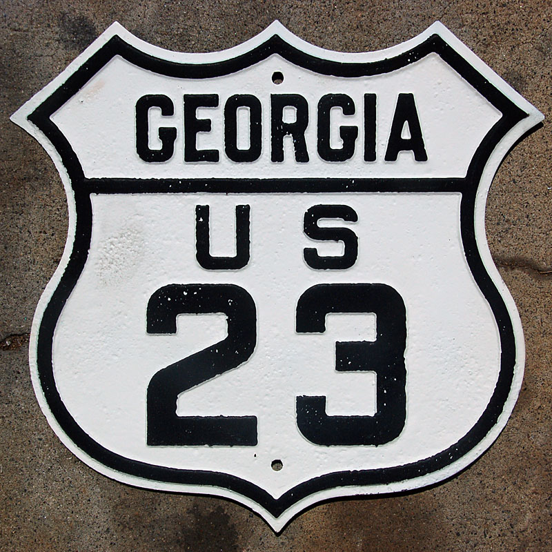 The front of the sign has been restored with white and black paint, and reflective glass beads.