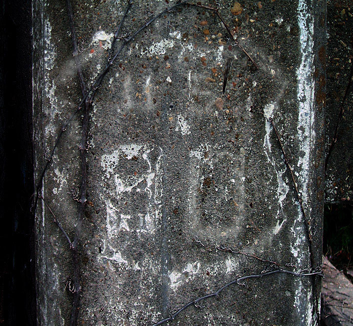 US-90 shield painted on the side of an old bridge.