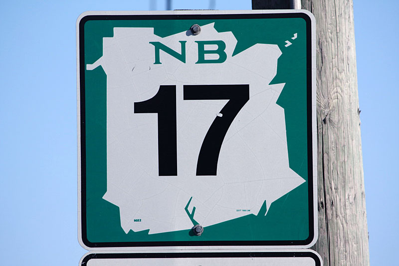 Three different styles of New Brunswick shields: green arterial (primary), blue collector (secondary), and black local (tertiary). Collector and arterial routes in Saint Leonard; local route in Grand Falls.