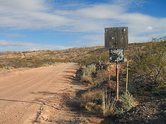 Decrepit 1950s US-54 highway marker on a long-abandoned alignment.