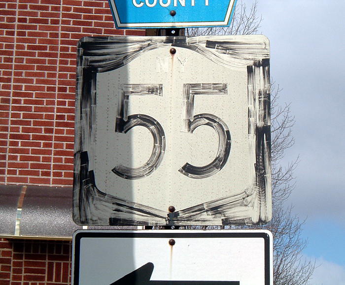 Hand-painted shield, with almost completely faded "NY".
