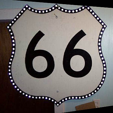 Replica of US-66 marker intended for green sign use. All genuine 66 shields of this style had reflector buttons on both the number and the border. This looks to have been a surplus blank, with the number printed on after the shield was retired, unused.