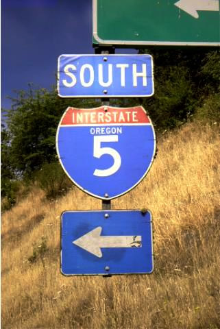 Wooden sign on west side of Interstate 5 at Exit 123 near Roseburg; replaced as of July 2003.