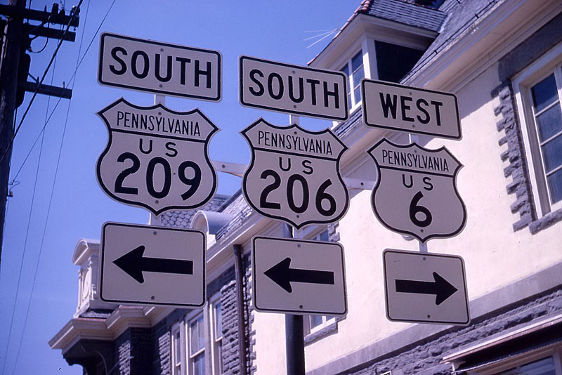<i>In my time at Rensselaer, I dated a nurse in Albany and we used to take road trips in her 1958 Volkswagen Beetle.  In April 1962 we went down to the NY-NJ-Pa tripoint.  This shot is in Milford, Penna, where US 206 meets US 6 and 209.  The significance is that US 206 ran into Pennsylvania just a very short distance, little more than a mile.  The second photo was taken last Thursday, in roughly the same spot.  Note that it says “TO US 206).”  The actual beginning of US 206 is now at the point where the route veers off to cross the Delaware River into NJ.  I would hazard a guess that the extent of US 206 in Pennsylvania is now no more than 100 yards.</i>