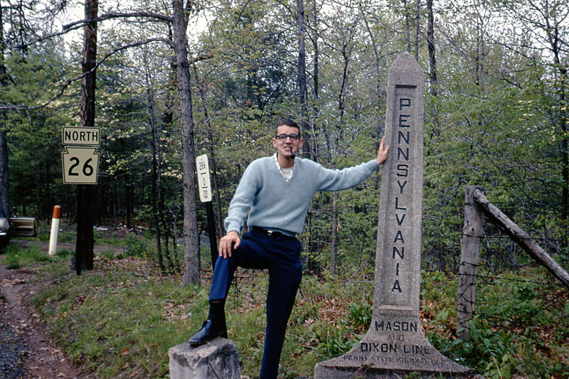 Inglesmith, at the Mason-Dixon Line.  <br><br>

<i>Here is a short-lived model of a Pennsylvania shield, albeit still a cutout.  The chap with his foot on the Mason-Dixon line is yours truly, at the tender age of 27.  I can’t explain why my sweater looks to be tucked into my pants!</i>