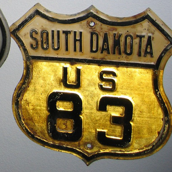 This is a 1920s or 30s shield that was retrofitted to meet 1950 specification, with the colored tab to identify the route number.  South Dakota used the colored shields from approximately 1950 to 1965.