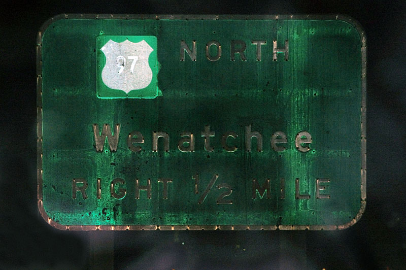 This guide sign dates back to 1957 and originally had an outline shield underneath the white patch.  The patch was added sometime in the early 1960s.