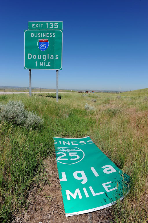A panel of this green sign has fallen off, revealing an incorrect shield underneath.
