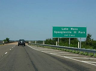 The next exit serves Lake Waco Speegleville III park. In the background, the beginning of the Lake Waco bridge.