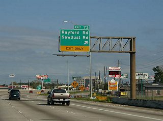 Exit 73 departs IH 45 northbound for Sawdust Road west into The Woodlands and Rayford Road southeast by an array of subdivisions to SH 99.