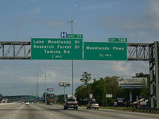 Commercialized frontage accompanies IH 45 north to the flyover (Exit 76) with Woodlands Parkway.