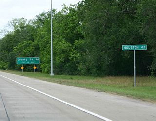 A small mileage sign touts the distance to downtown Houston on Texas 288 north, one half mile south of Brazoria County Route 44 (Anchor Road). Anchor Road and Texas 288 meet at a diamond interchange northwest of Angleton near Holiday Lakes.