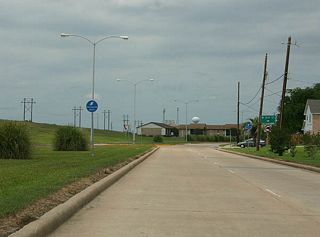Texas 288 begins at the Texas 36 intersection with FM 1495 (Pine Street) in Freeport. The two highways travel concurrently to a folded diamond interchange with Brazosport Boulevard, where Texas 288 turns northward. Brazosport Boulevard parallels a levee along the Brazos River and intersects 8th Street in this scene.