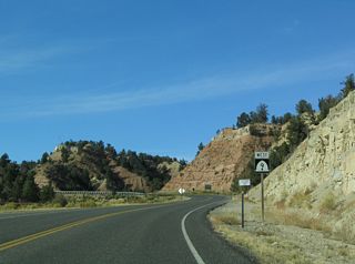The first shield along westbound SR 9 stands ahead of a sweeping curve taking the state route southwest.