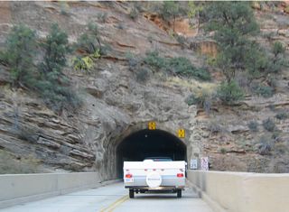 The Zion-Mount Carmel Tunnel, which passes under Bridge Mountain, was constructed in the 1920s, and it was designed with no interior lights, occasional glimpses to the valley below through open vents, and a small size since it was designed to accommodate small vehicles from another era. Vehicles sized 7'10" in width or 11'4" in height, or larger, must have an escort through the Zion-Mount Carmel Tunnel.