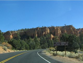 Mileage sign along eastbound Utah 12 in the vicinity of Red Canyon, indicating that Bryce Canyon is 14 miles ahead (via Utah 12 and Utah 63).
