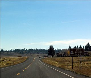 Now departed from Red Canyon, east Utah 12 approaches Utah 63 and Garfield County Route 1660 at Rubys Inn. The main function of Utah 63 is to funnel traffic into Bryce Canyon National Park, as evidenced by the brown guide sign used for the pending junction.