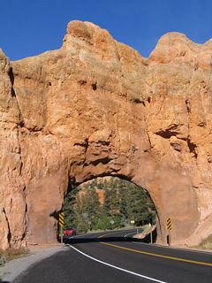 Westbound Utah 12 approaching the first of two tunnels in the Red Canyon area. These two tunnels allow Utah 12 to pass under two of the red rock formations without having to pass over the riverbed to the south.