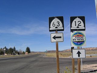 These shields are located on westbound Utah 12 at the intersection with Utah 63. Unsigned Garfield County Route 1660 continues north from this intersection to meet Utah 22 in Antimony; Utah 63 heads south a few miles to the northern entrance to Bryce Canyon National Park. The close-ups show the detail of the state route shields and the scenic byway shield.