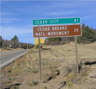 Mileage sign on westbound Utah 14 for Cedar Breaks National Monument and Cedar City.