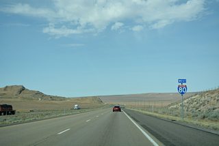 Interstate 80 descends from the Cedar Mountains area toward the Great Salt Lake Desert, a vast expanse of salt flats.
