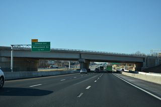 A Left Exit follows U.S. 50 from the I-66 Express Lanes for Monument Drive  west of Fair Oaks Mall.