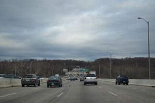 A nondescript concrete span carries eight lanes of Interstate 495 at Chesapeake and Ohio Canal National Historical Park. The directional cloverleaf interchange (Exit 41) with Clara Barton Parkway follows.