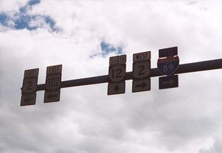 A mast arm with route markers preceded the intersection joining U.S. 2 Business/VT 12 (Main Street) south with U.S. 2 (Memorial Drive).