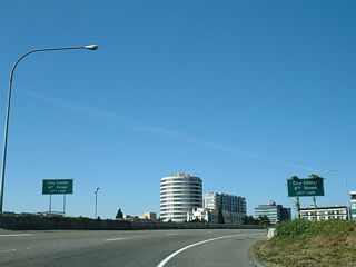 The ramps from Exit 1 B and SR 14 west combine ahead of the left turn onto 6th Street into the Vancouver city center. These signs were amended by 2019 to display Waterfront in place of 6th Street.