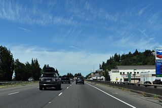 Interstate 5 north at milepost 30 in Kalama. The freeway is slightly elevated above parallel NE Frontage Road.