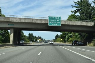 The speed limit lowers to 60 miles per hour north between the Israel Road overpass and a commercialized parclo interchange (Exit 102) with Trosper Road.