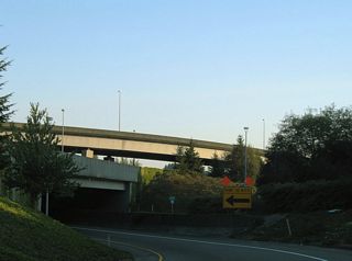 An entrance ramp from adjacent Deschutes Way joins the ramp from I-5 north at Exit 104 leading into the directional T interchange with U.S. 101.