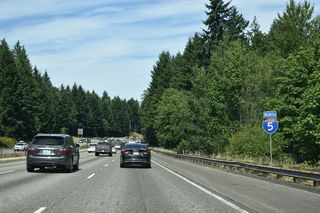 Interstate 5 shifts northeast from Exit 109 through a wooded area before resuming eastward across Woodland Creek.
