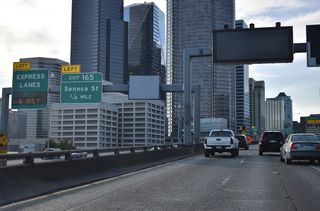 The Express Lanes shift onto a separate roadway ahead of Left Exit 165 onto Seneca Street west at Central Freeway Park.