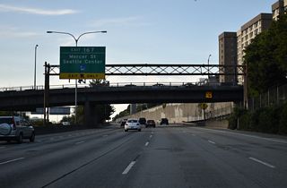 Exit 167 leaves I-5 north at the Denny Way overpass west of Seattle Central Community College and descends into a cut and cover tunnel before combining with the southbound off-ramp ahead of Fairview Avenue. Mercer Street carries a significant amount of traffic between I-5 and SR 99 (Aurora Avenue), north of Downtown and south of Queen Anne Hill.