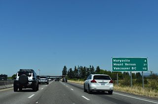 I-5 runs alongside Langus Riverfront Park by this distance sign posted 31 miles from the Skagit County seat of Mount Vernon and 112 miles from Vancouver, British Columbia via B.C. Highway 99.