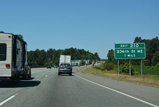 The diamond interchange (Exit 210) with 236th Street NE lies midway between the Stillaguamish River and Pilchuck Creek.