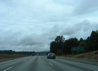 Distance sign posted 17 miles from Mount Vernon and 44 miles from the Whatcom County seat of Bellingham.