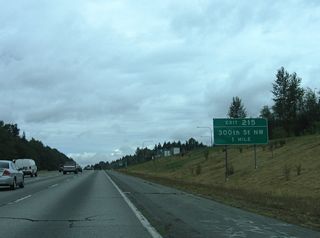 The diamond interchange (Exit 215) with 300th Street NW is one mile north of the weigh station.