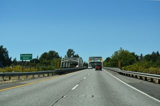 Interstate 5 spans the Nooksack River across a pair of steel through truss bridges.